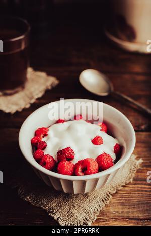 Dessert sain avec framboise mûre et crème dans un bol Banque D'Images
