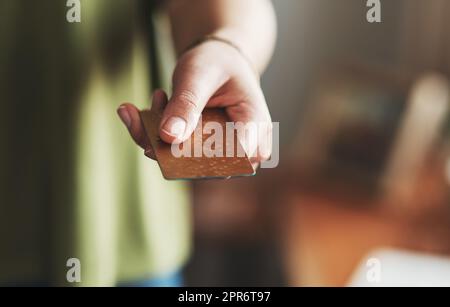 Prenez mon argent. Photo rognée d'une femme d'affaires non reconnaissable debout seule dans son bureau à domicile et tenant sa carte de crédit. Banque D'Images