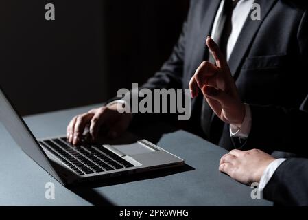 Homme tapant sur Lap Top et femme pointant d'un doigt sur message important. Homme d'affaires écrivant sur ordinateur et femme d'affaires présentant des informations crutiales. Banque D'Images