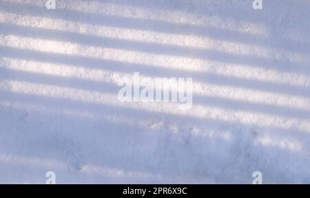 Arrière-plan avec ombres des arbres dans la neige en hiver ensoleillé Banque D'Images