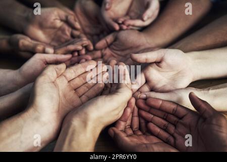 Montrez votre soutien à notre cause. Prise de vue rognée d'un grand groupe de personnes non identifiables en se plongeant les mains ensemble. Banque D'Images