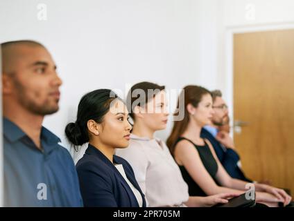 Prêt à impressionner. Photo d'un groupe d'hommes d'affaires assis en file d'attente en attendant d'être interviewés. Banque D'Images