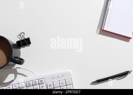 Informations importantes présentées sur le bureau avec un stylo, un carnet, un trombone, du café et un clavier. Message de base sur la table avec clip, gobelet, crayon et note. Banque D'Images