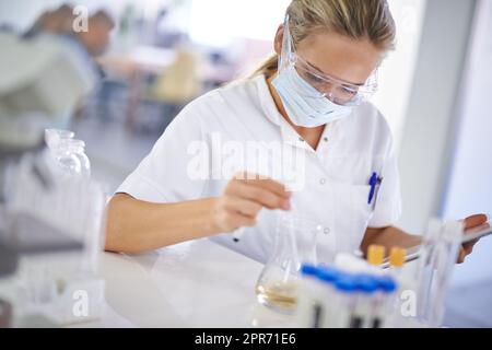 Tester une théorie. Un jeune scientifique effectuant une expérience dans son laboratoire. Banque D'Images