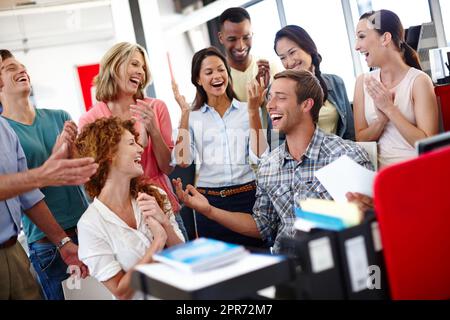 J'ai réussi. Photo d'un groupe diversifié de collègues célébrant les bonnes nouvelles au bureau. Banque D'Images