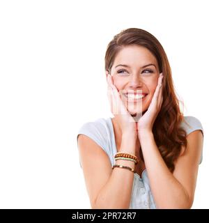 Je suis tellement enthousiaste, et je ne peux tout simplement pas le cacher. Une jeune femme qui pense sur fond blanc. Banque D'Images