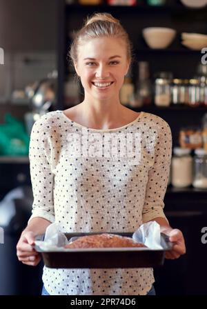 Pain maison sain - vous devriez en essayer. Portrait d'une jeune femme tenant un pain fraîchement cuit dans une casserole. Banque D'Images