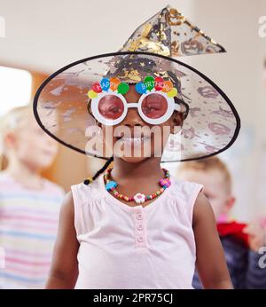 Laissez libre cours à votre imagination. Photo d'une petite fille jouant de l'habillage en classe. Banque D'Images