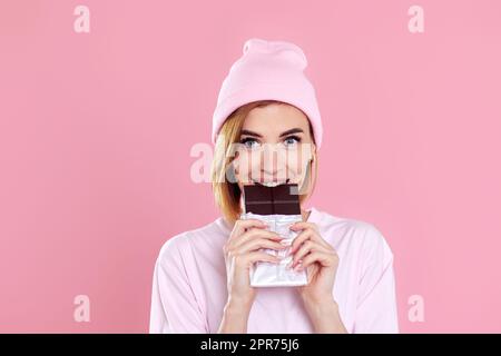 jeune femme heureuse dans un t-shirt décontracté bite au chocolat doux Banque D'Images