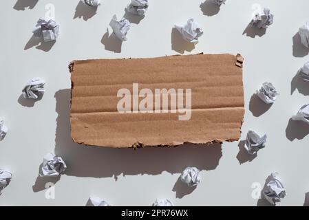 Des emballages en papier placés sous le carton contenant des renseignements importants. Les notes froissées sont placées sous le carton avec le message de base. Mémos froissé avec données critiques ci-dessus. Banque D'Images