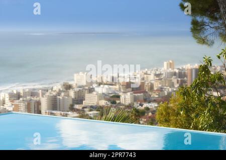 Vue panoramique de la piscine à débordement surplombant Sea point au Cap, Afrique du Sud avec fond océanique. Bureau extérieur de luxe, sur le toit dans un appartement, une maison, un hôtel. Paysage urbain, horizon de la ville Banque D'Images