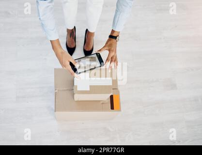 Heres preuve de votre colis. Photo en grand angle d'une femme méconnaissable prenant une photo de boîtes pour livraison. Banque D'Images