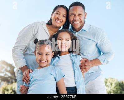 Rien n'est plus important que de passer du temps avec votre famille. Photo d'un couple debout à l'extérieur avec leurs deux filles. Banque D'Images