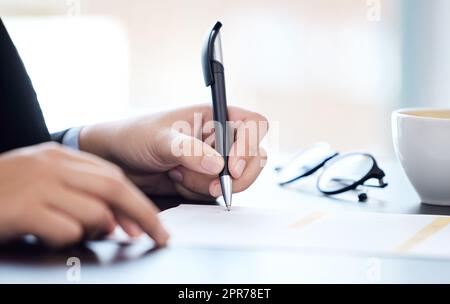 Je n'aurais pas aimé que cela soit plus facile. Je vous souhaite une meilleure qualité. Photo d'une femme d'affaires méconnaissable qui passe par la paperasse dans un bureau moderne. Banque D'Images