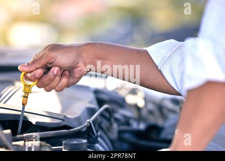 Peut-être son huile. Photo d'un homme méconnaissable qui se présente sous le capot de sa voiture après avoir subi une panne de véhicule. Banque D'Images