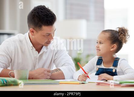 Le meilleur professeur, un jeune père aidant sa fille à faire ses devoirs à la maison. Banque D'Images