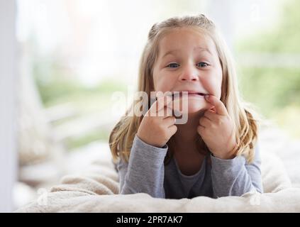 Je vous ai fait regarder. Une jeune fille faisant des visages drôles à la maison. Banque D'Images