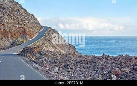 La Palma Island route de montagne pour un trajet jusqu'au sommet de la falaise sur une route sinueuse au bord de l'océan. Vue sur la côte en Espagne itinéraire côtier courbe avec ciel bleu nuageux et mer sur fond. Banque D'Images