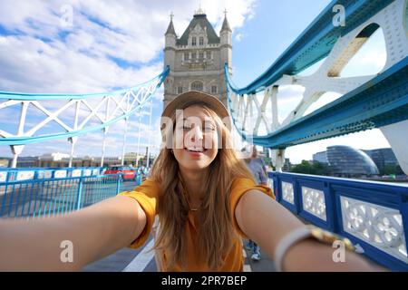 Une fille souriante prend une photo de selfie sur Tower Bridge à Londres, au Royaume-Uni Banque D'Images