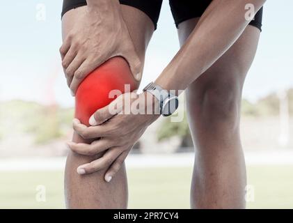 Gros plan d'un sportif tenant son genou douloureux en rouge éclatant. Athlète inconfortable souffrant d'une blessure douloureuse à la jambe et d'une inflammation des muscles pendant l'entraînement. Tension musculaire due à un effort excessif Banque D'Images