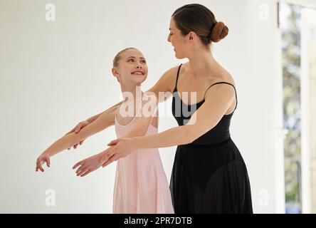 Rester engagé, motivé et inspiré. Une jeune fille pratiquant le ballet avec son professeur dans un studio de danse. Banque D'Images