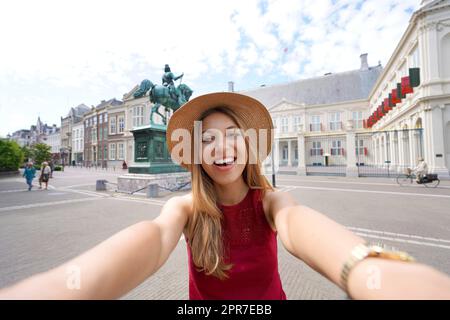 Heureuse touriste qui se fait autoportrait devant le palais de Noordeinde à la Haye, pays-Bas Banque D'Images