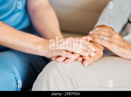 Tout ce qu'il faut pour changer une vie est une certaine gentillesse. Gros plan d'une infirmière méconnaissable tenant confortablement une main de femme âgée. Banque D'Images