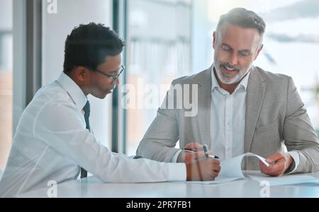 Nous avons tous besoin d'un mentor. Deux hommes d'affaires signent un contrat dans un bureau. Banque D'Images