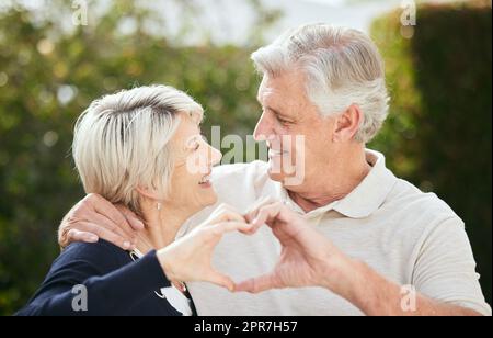 Mon cœur sera toujours le vôtre. Un couple senior formant une forme de coeur avec leurs mains. Banque D'Images