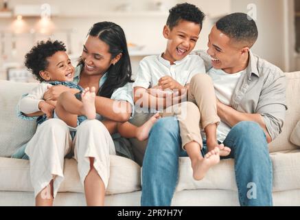 Ma mère tient notre coeur. Une jeune famille se liant volontiers sur le canapé à la maison. Banque D'Images