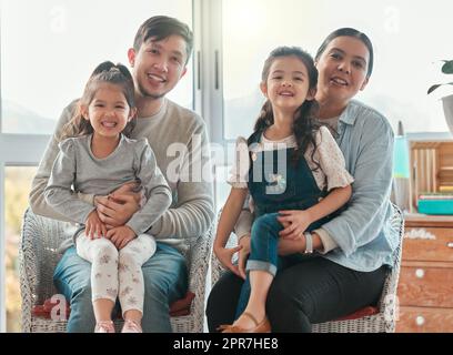 La maison est un sentiment pas un endroit. Crier d'un couple assis à la maison avec leurs deux filles. Banque D'Images