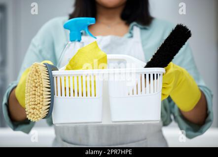 Où commencer. Une femme tenant un panier avec des fournitures de nettoyage. Banque D'Images