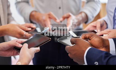 Aimez et partagez notre page. Un groupe d'hommes d'affaires méconnus utilisant leur téléphone portable. Banque D'Images