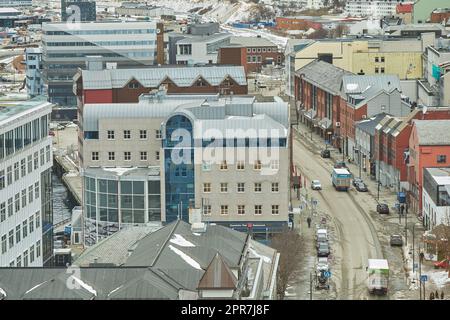 Vue aérienne de la ville de Bodo en Norvège avec une route principale très fréquentée. Un paysage urbain moderne et pittoresque de rues et de bâtiments près d'une montagne enneigée en hiver avec espace de copie. Paisible ville rurale d'en haut Banque D'Images