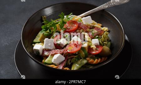 Salade de pâtes italiennes concombres, tomates cerises, olives, oignons rouges, salami, Fromage feta et rotini Banque D'Images