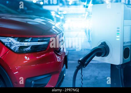 Charge de voiture à la station de charge de voiture électrique. Station de charge de véhicule électrique pour charger la batterie EV. Point de charge sur le parking. Énergie propre et durable. Point de charge de véhicule électrique commercial. Banque D'Images