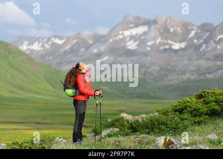 Randonneur rouge au repos et respirant de l'air frais dans la montagne Banque D'Images