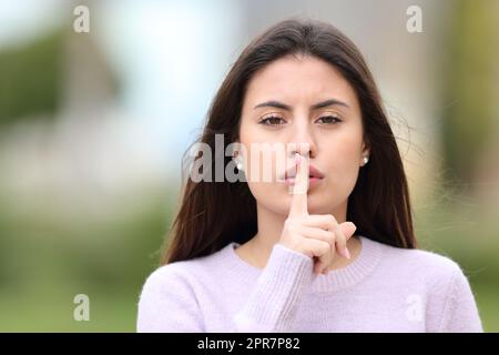 Un adolescent sérieux qui demande le silence dans la rue Banque D'Images