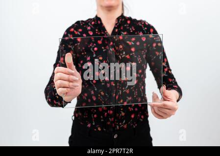 Femme professionnelle portant un T-shirt fleuri tenant un verre transparent et affichant des données de vente importantes. Femme avec bannière rectangulaire faisant la promotion de la marque de l'entreprise. Banque D'Images