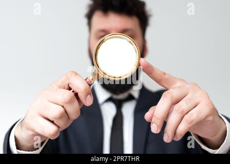 Homme d'affaires tenant la loupe d'une main. Homme ayant une loupe pour signaler des informations importantes. Homme Zooming message crutial. Cadre présentant une nouvelle idée. Banque D'Images