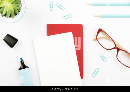 Annonces importantes sur une feuille de papier au-dessus du Bloc-notes sur le bureau avec fleur, lunettes et clavier. Informations de base sur le carnet de notes sur la table avec crayon. Banque D'Images