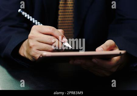 L'homme d'affaires signe le contrat de tablette numérique en ligne dans l'application sur le bureau. Banque D'Images
