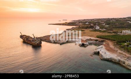 Vue aérienne à vol d'oiseau de l'épave du navire abandonné EDRO III à Pegeia, Paphos, Chypre d'en haut au coucher du soleil. Le naufrage rouillé s'est retrouvé coincé sur le rocher de Peyia Banque D'Images