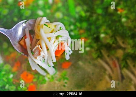 cuillère pleine avec pâte de carottes et morceaux de poulet sur le fond de la soupe aux légumes. cuisinez à la maison Banque D'Images