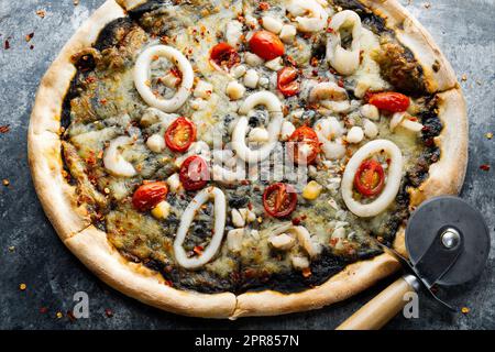 pizza de fruits de mer noire à l'encre de calmar italienne rustique Banque D'Images