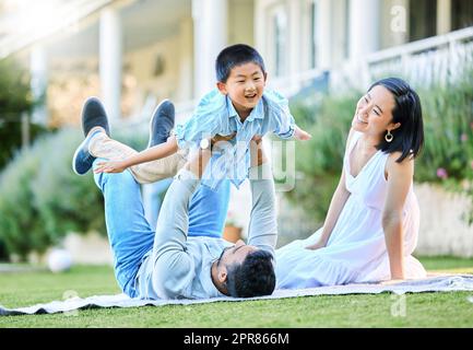 Des moments de détente, des moments en famille. Photo d'une jeune famille qui se détend dans son jardin à l'extérieur. Banque D'Images