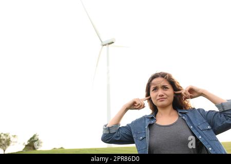 Femme en colère couvrant les oreilles écoutant le bruit du moulin à vent Banque D'Images