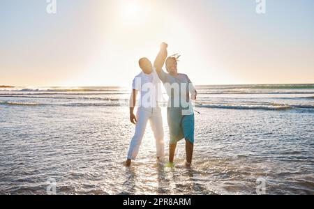 Partager un moment romantique. Photo d'un jeune couple affectueux dansant ensemble à la plage. Banque D'Images