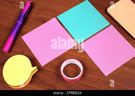 Informations importantes écrites sur trois notes différentes sur le bureau avec téléphone portable et cassette. Messages essentiels sur les mémos de la table. Annonces critiques présentées sur papier. Banque D'Images