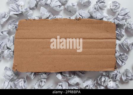 Des emballages en papier placés sous le carton contenant des renseignements importants. Notes froissées placées sous le carton avec une idée cruelle. Mémos froissé avec données critiques ci-dessus. Banque D'Images